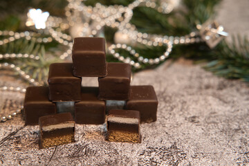 Stacked dominoes in front of fir greenery and Christmas chain