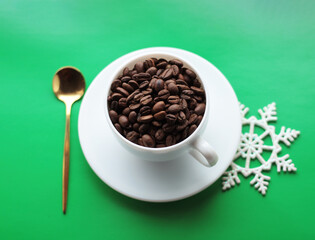 cup of coffee on a saucer on a green background, golden spoon