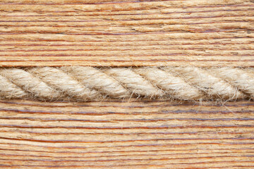 Fototapeta na wymiar Linen rope in wooden wall background. Heat isolation system. Antique style mountain hut closeup interior wall texture. Wood pattern lines.