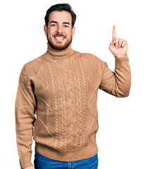 Young hispanic man wearing casual clothes showing and pointing up with finger number one while smiling confident and happy.