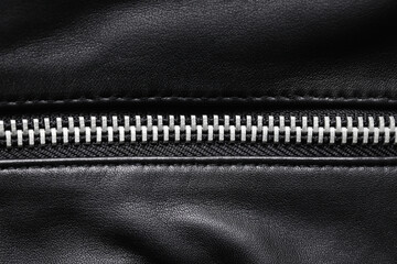 Black leather jacket background. Autumn clothing. Autumn winter fashion texture. Closed fastener....