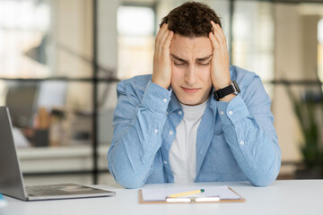 Sad tired despaired young european man manager hold head with hands, suffer from mistake