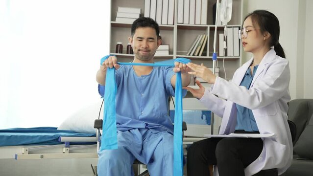 Nurse helping physical therapy of male patient at hospital, Asian female physical therapist working and helping protect patient's hands. Patient stretches muscles in clinic 4k