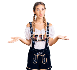 Beautiful caucasian woman with blonde hair wearing octoberfest traditional clothes clueless and confused expression with arms and hands raised. doubt concept.