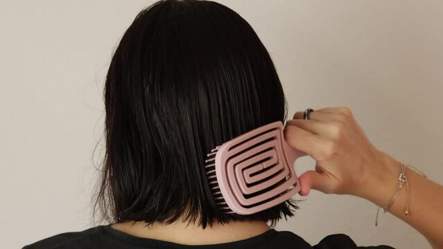 gros plan sur une femme se brossant les cheveux