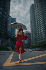 Careless young woman walking in the rain on a city street umbrella
