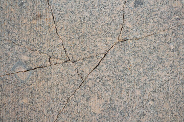 Abstract textured grey granite background. Close-up view of mottled stone surface with cracks. Soft focus. Copy space for your text or decoration. Real stone backdrop. Construction material theme.