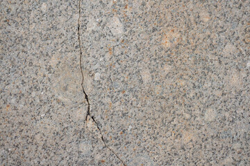 Abstract textured grey granite background. Close-up view of mottled stone surface with cracks. Soft focus. Copy space for your text or decoration. Real stone backdrop. Construction material theme.