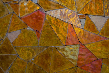 Abstract mosaic wall background. Close-up view of orange shiny tiled mosaic wall looking like stained glass. Copy space for your text ordecoration. Soft focus. Building decoration theme.