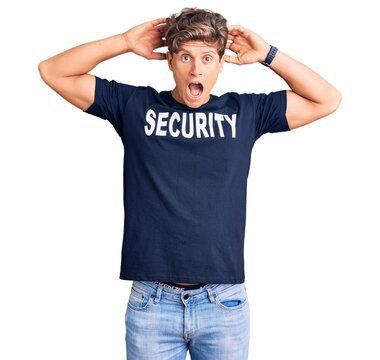 Young handsome man wearing security t shirt crazy and scared with hands on head, afraid and surprised of shock with open mouth