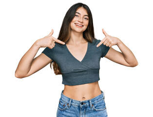 Young beautiful teen girl wearing casual crop top t shirt looking confident with smile on face,...