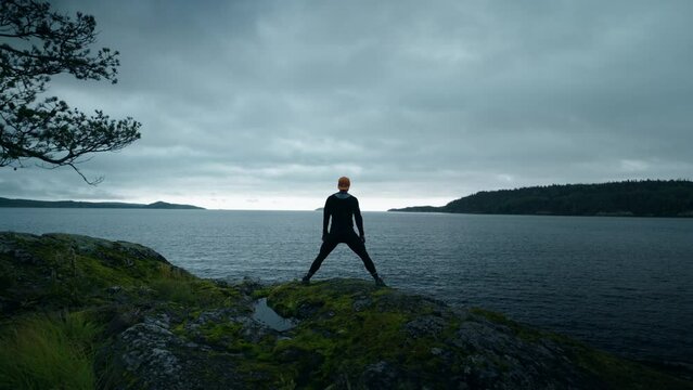 Squatting Sportsman At Top Of Mount, View On Fitness Coach From Drone, Future Champion