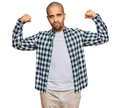 Hispanic adult man wearing casual clothes showing arms muscles smiling proud. fitness concept.