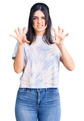 Young beautiful girl wearing casual t shirt smiling funny doing claw gesture as cat, aggressive and...