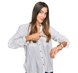 Young beautiful woman wearing casual clothes in hurry pointing to watch time, impatience, upset and...