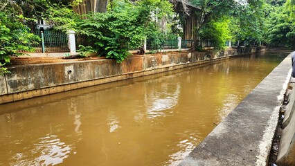 atmosphere on the riverside in the city of Jakarta. The color of the river is turbid brown