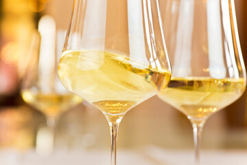Glasses with white wine in a festive room for a celebration - selective focus