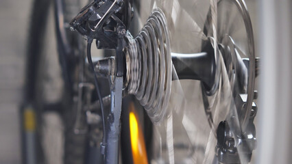 Rotating mountain bike drivetrain, brake disc and wheel spokes. Close-up. Bicycle repair and...