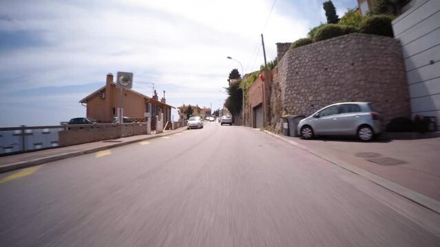 Point Of View Cars Moving On Road By Houses Under Clouds In Sky - Monte Carlo, Monaco