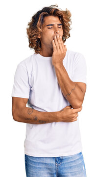 Young hispanic man wearing casual white tshirt bored yawning tired covering mouth with hand. restless and sleepiness.