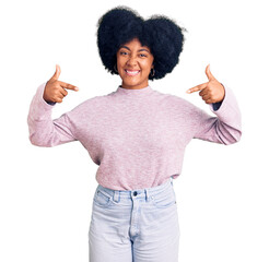 Young african american girl wearing casual clothes looking confident with smile on face, pointing oneself with fingers proud and happy.