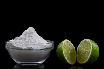 Baking soda, vinegar and cut lemons on blac bacgrondtable, flat lay. Space for text
