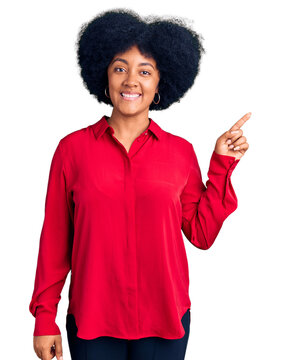Young african american girl wearing casual clothes with a big smile on face, pointing with hand finger to the side looking at the camera.