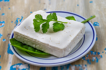 Cube Feta cheese isolated on white background clipping Heap of Feta cheese, basil leaves and tomatoes.