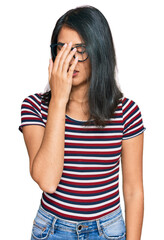 Beautiful asian young woman wearing casual clothes and glasses tired rubbing nose and eyes feeling fatigue and headache. stress and frustration concept.