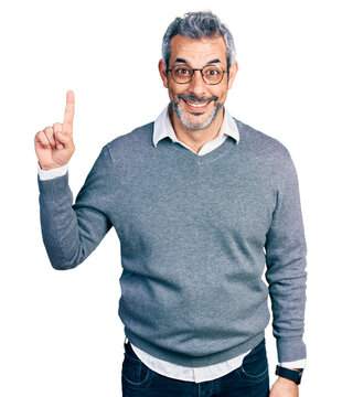 Middle age hispanic with grey hair wearing glasses showing and pointing up with finger number one while smiling confident and happy.