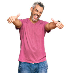 Middle age grey-haired man wearing casual clothes approving doing positive gesture with hand, thumbs up smiling and happy for success. winner gesture.