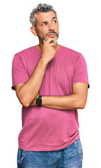 Middle age grey-haired man wearing casual clothes with hand on chin thinking about question,...