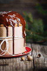Christmas Panettone Cake with Melted Chocolate on Rustic Wooden Board and Festive Decorations - Holiday Dessert from Milan, Italy. 