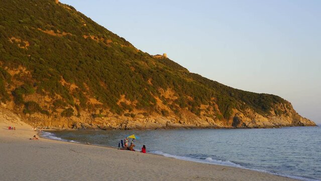 People on Solanas beach at sunset in Sardinia, Italy