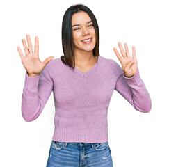 Young hispanic girl wearing casual clothes showing and pointing up with fingers number nine while...