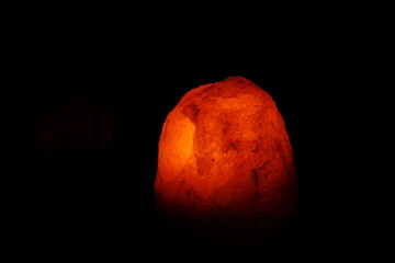 red salt lamp on the black background in the night