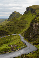 Cyclist pedaling up a windy road in the Trotternish Ridge on the Isle of Skye