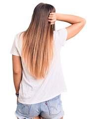 Beautiful caucasian woman wearing casual white tshirt backwards thinking about doubt with hand on head