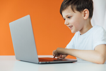 schoolboy studying at the computer homeschooling student education lessons boy online school in the classroom