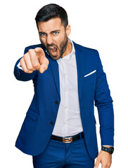 Young hispanic man wearing business jacket pointing displeased and frustrated to the camera, angry and furious with you