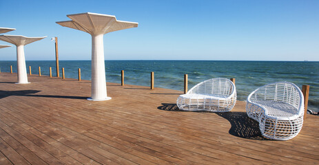 Modern white rattan furniture to create an outdoor pool in living room by sea. Luxurious swimming...
