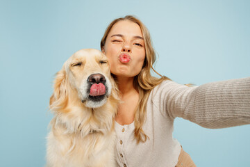 Close up young owner woman with her best friend retriever dog wear casual clothes do selfie shot pov mobile cell phone wink isolated on plain pastel light blue background. Take care about pet concept.