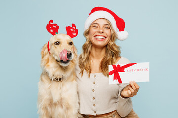 Young owner woman with wears casual clothes Santa hat hug best friend retriever dog hold store gift...