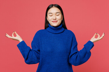 Young spiritual woman of Asian ethnicity wear blue sweater casual clothes hold spreading hands in...