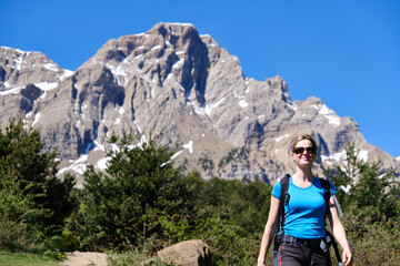 Woman hiking on a sunny day with the mountains in the background