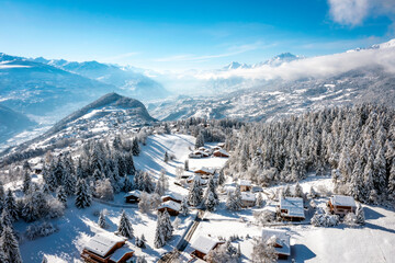 The Rhone valley in winter, in the Valais Alps, Switzerland from Crans-Montana ski resort with the villages of Lens, Icogne, Ayent and the town of Sion. - obrazy, fototapety, plakaty