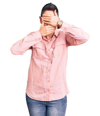 Fototapeta premium Young woman with short hair wearing casual clothes covering eyes and mouth with hands, surprised and shocked. hiding emotion