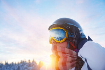 Close up of the ski goggles of a woman with the reflection of snowed mountains. Ski Woman on the sunset background. Winter Sports. - Powered by Adobe