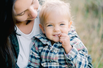 Smiling little girl in the arms of her mother looking at her. Portrait