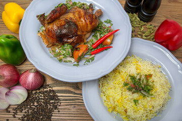 Half grilled chicken with pulao rice biryani, black pepper, bell peppers, tomato and onion served in dish isolated on table top view of arabic food